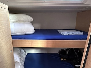 A bunk bed with a blue mattress and white pillows.