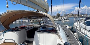 A sailboat's deck with a steering wheel, ropes, and a view of the marina. - Sun-Kissed Sailing Adventure in Provence-Alpes-Côte d'Azur (Grimaud)