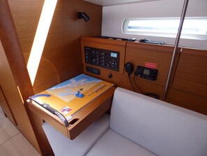 A control panel with various buttons and a map, a small table with a map and a keychain, and a window with a view of the sky. - Sun-Kissed Sailing Adventure in Split, Croatia (Kaštel Gomilica)