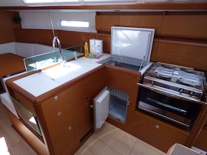 A compact kitchen with a sink, a small refrigerator, and a stove.