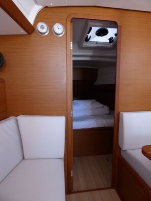 A compact cabin with a bunk bed, a small window, and a wall clock. - Sun-Kissed Sailing Adventure in Split, Croatia (Kaštel Gomilica)