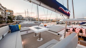 A marina with boats, a dining area with a table and chairs, and a view of buildings in the background.