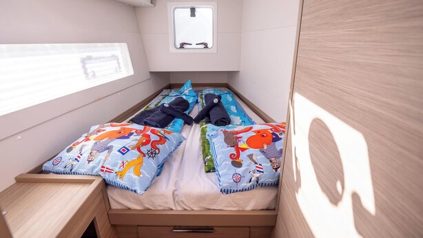 Una camera da letto piccola e compatta con un letto singolo, una finestra e un tavolino.