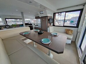 A compact kitchen with a dining area, a bench, and a view through the window.