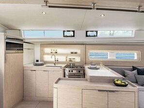A compact kitchen with a stove, sink, and a small dining area.