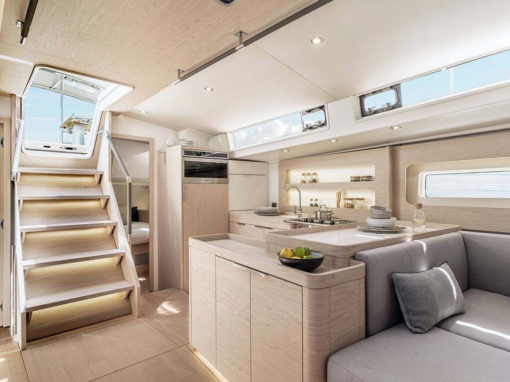 Een modern interieur met een keuken, eethoek en een trap naar een hoger gelegen verdieping.