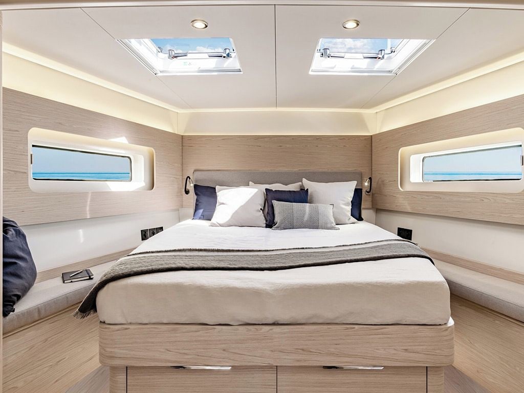 A modern bedroom with a bed, skylights, and windows.