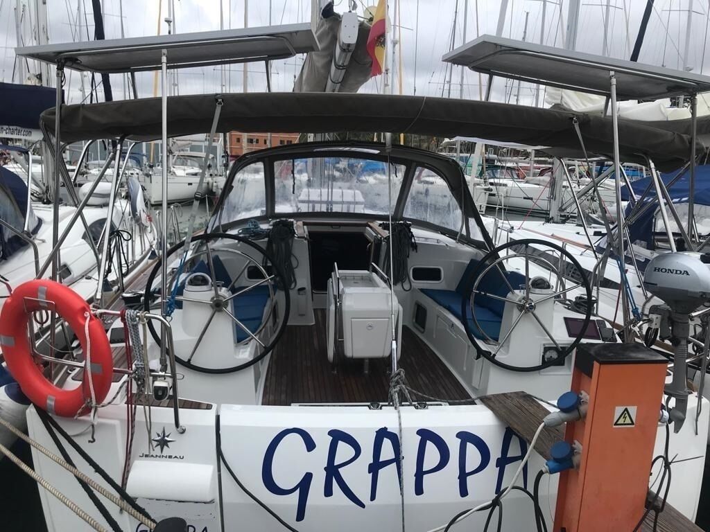 Un bateau nommé « GRAPPA », équipé d’un volant, d’une bouée de sauvetage et d’un espace cabine.