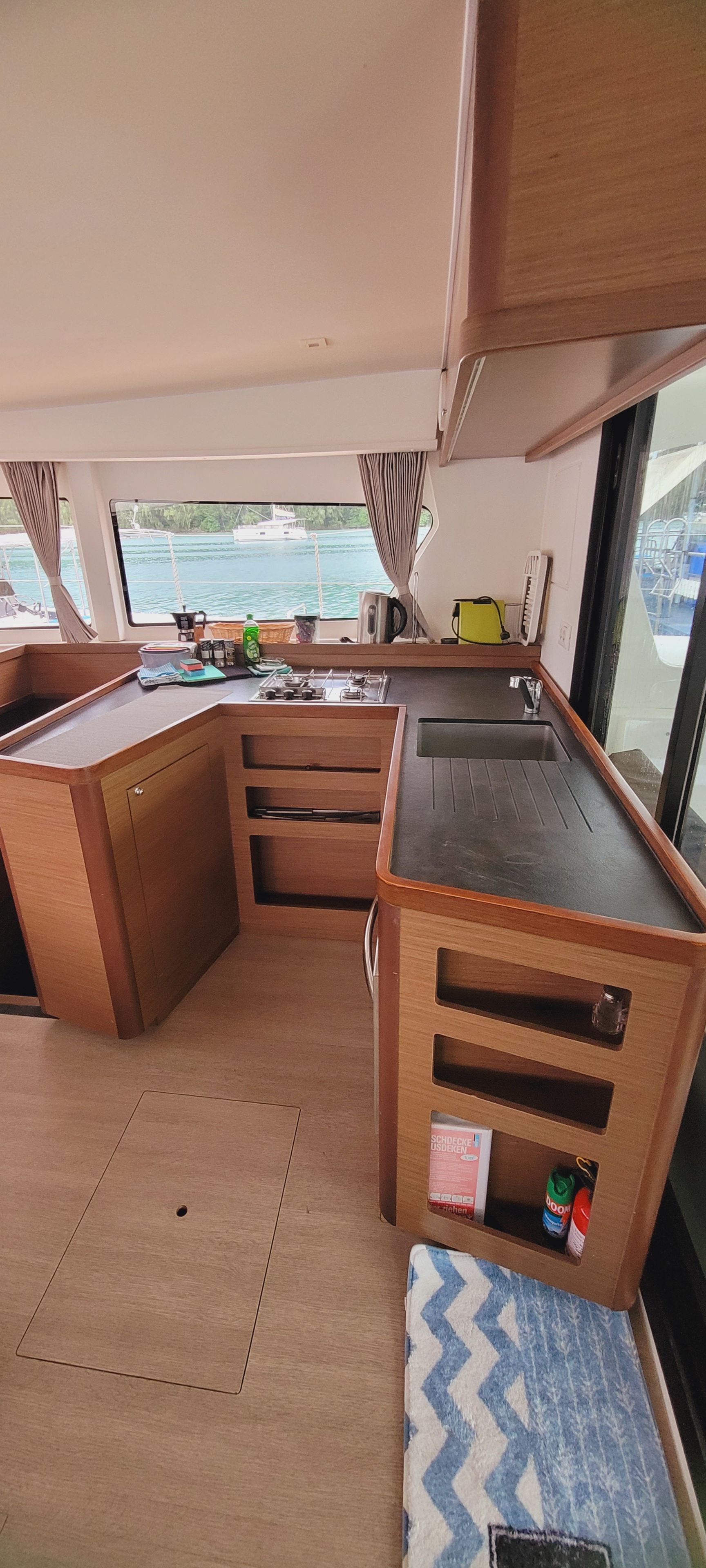 A compact galley with a sink, stove, and storage cabinets.