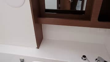 Et badeværelse med badekar, vask og toilet.