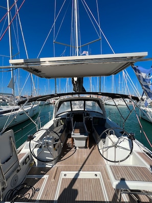 Ein Bootsdeck mit Steuer, Bedienfeld und Sitzgelegenheiten.