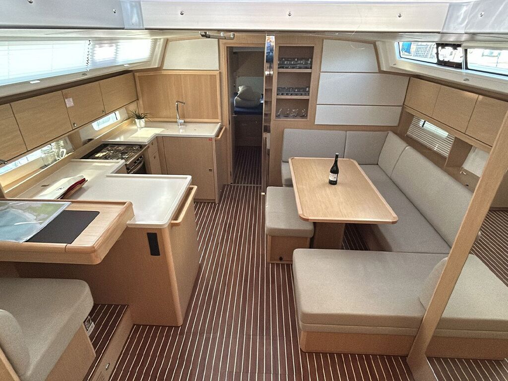 A compact galley with a stove, sink, and seating area.