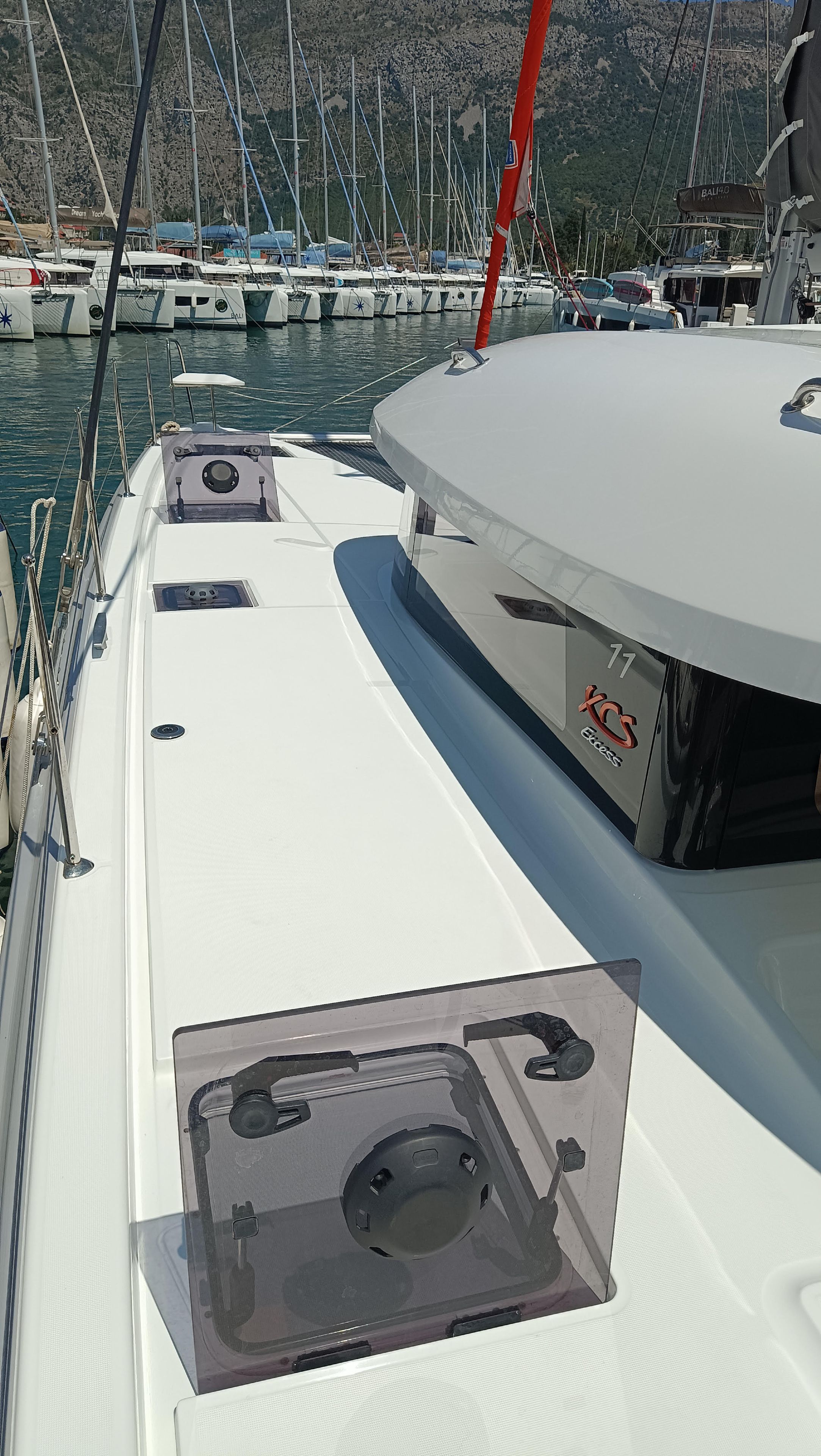 Das Deck eines Bootes mit freiem Blick auf das Wasser und andere Boote im Hintergrund.