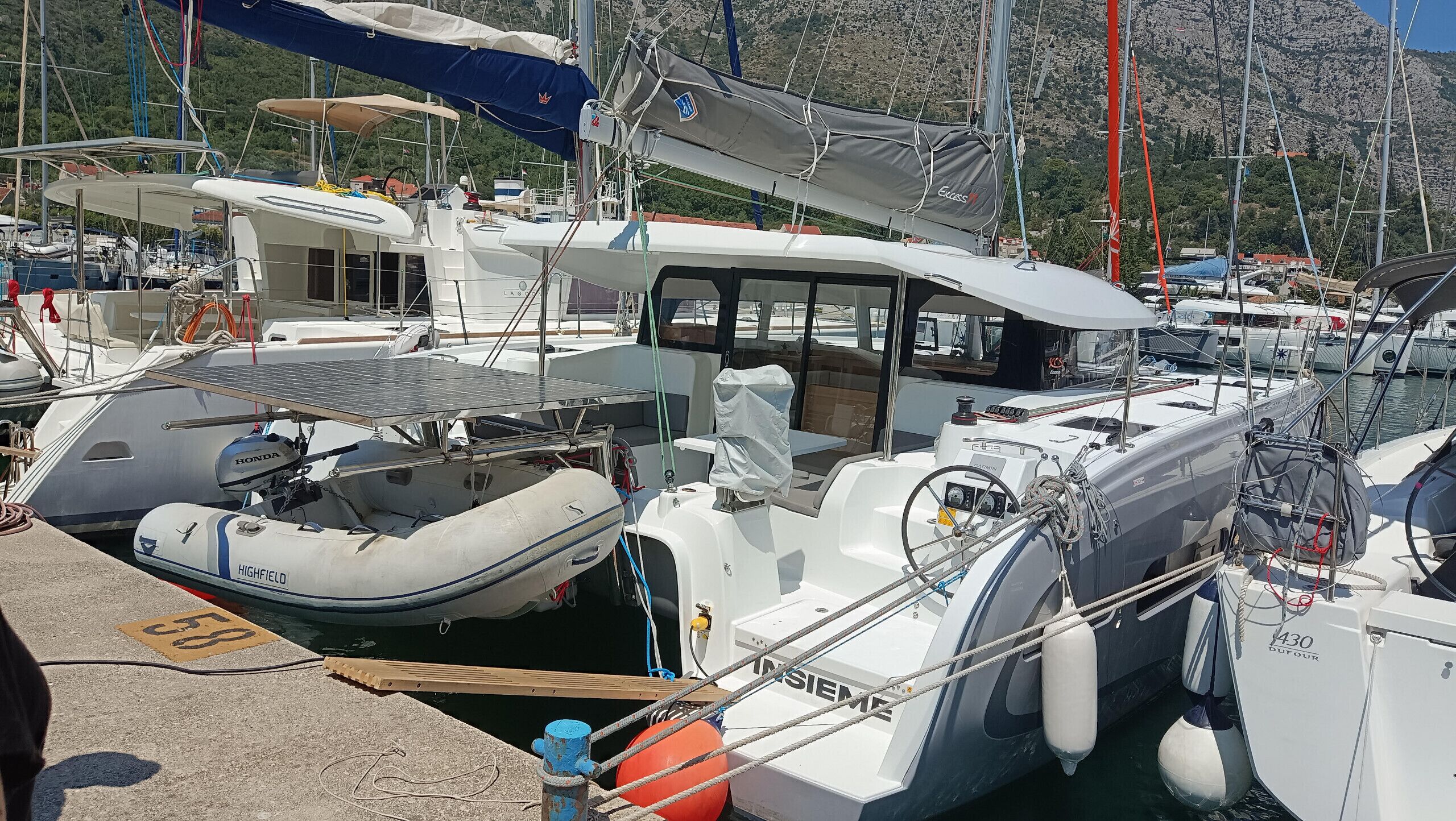 Ein Yachthafen mit vertäuten Booten, darunter eine weiße Yacht mit der Aufschrift 'HIGHFIELD'.