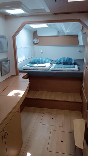 Ein kleines Zimmer mit einem Bunkelbett, einem kleinen Schreibtisch und einem Stauraumschrank.