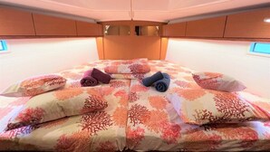 Ein Bett mit floralem Muster, Kissen und gefalteten Handtüchern.