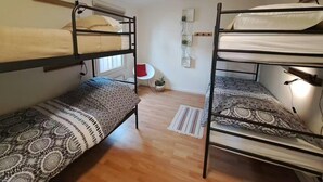 A dormitory room with bunk beds, a small table, a chair, and a window. - Nature Base Near Fishing Waters (Heinkenszand)