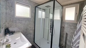 A modern bathroom with a glass shower enclosure, a white sink, and a radiator. - Nature Base Near Fishing Waters (Heinkenszand)