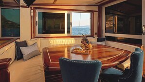 Un comedor con una mesa de madera, sillas tapizadas en azul y un frutero.