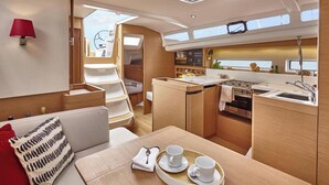 A compact galley with a sink, stove, and a small dining area with a tray of cups and a spoon. - Sun-Kissed Sailing Adventure in Islas Baleares, Mallorca (Palma)