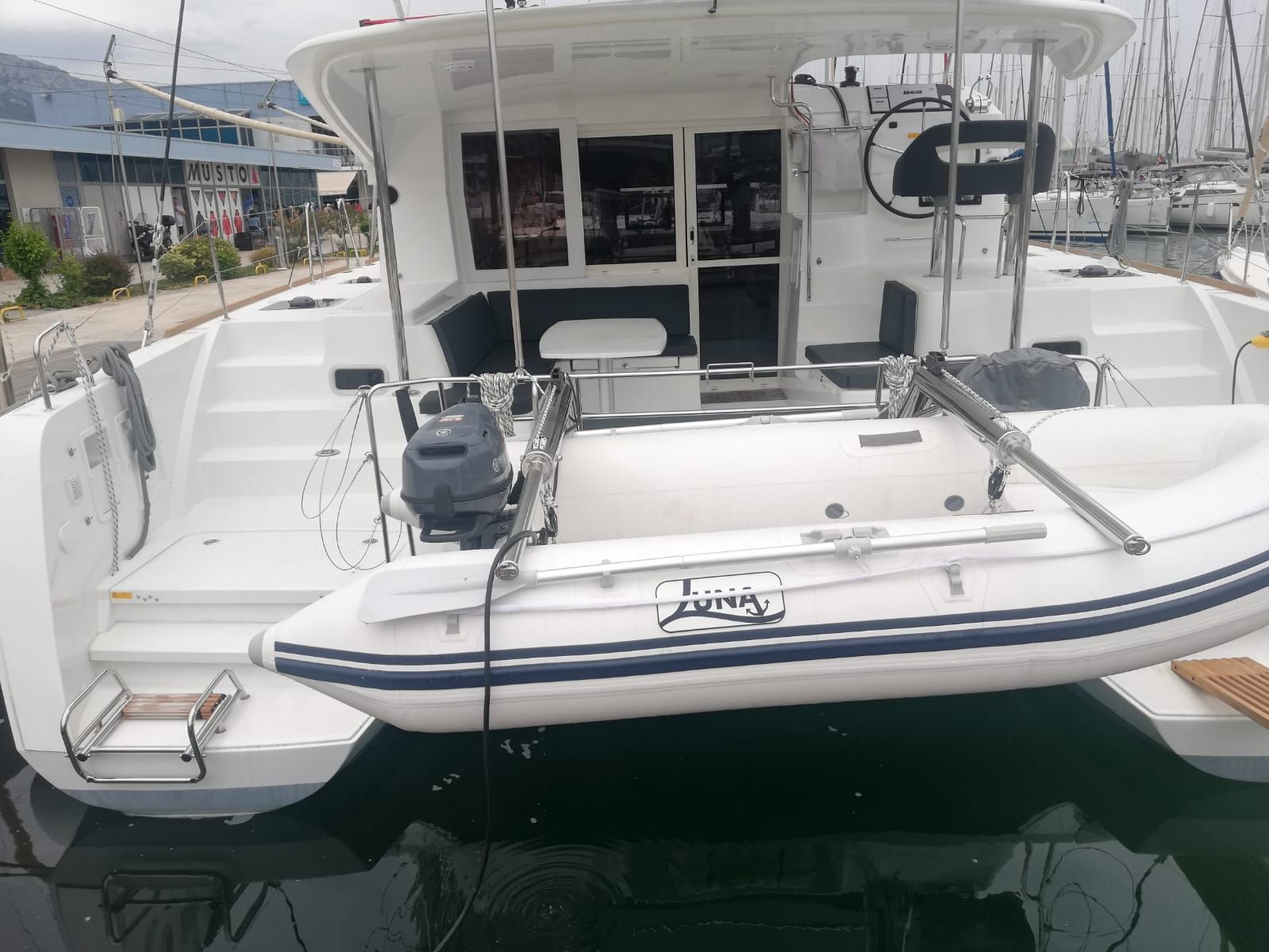 A white boat with a cabin, a motor, and a brand name 'LUNA' on the side.