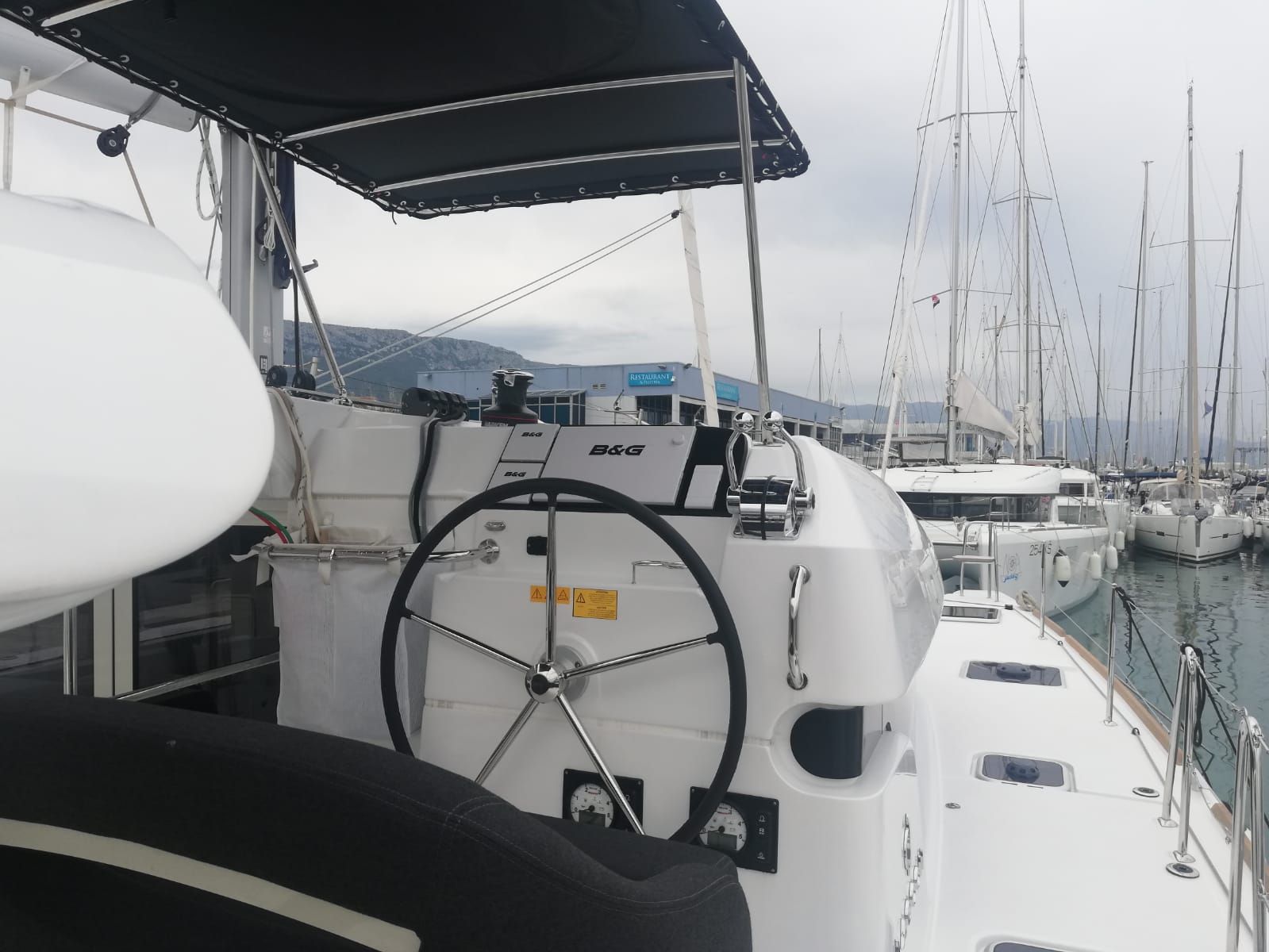 Un poste de commande de bateau équipé d’un volant, d’un treuil et d’une bouée de sauvetage.