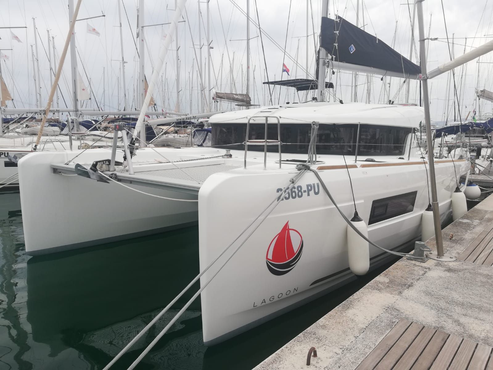 A white yacht docked at a marina with the number 2568-PU.
