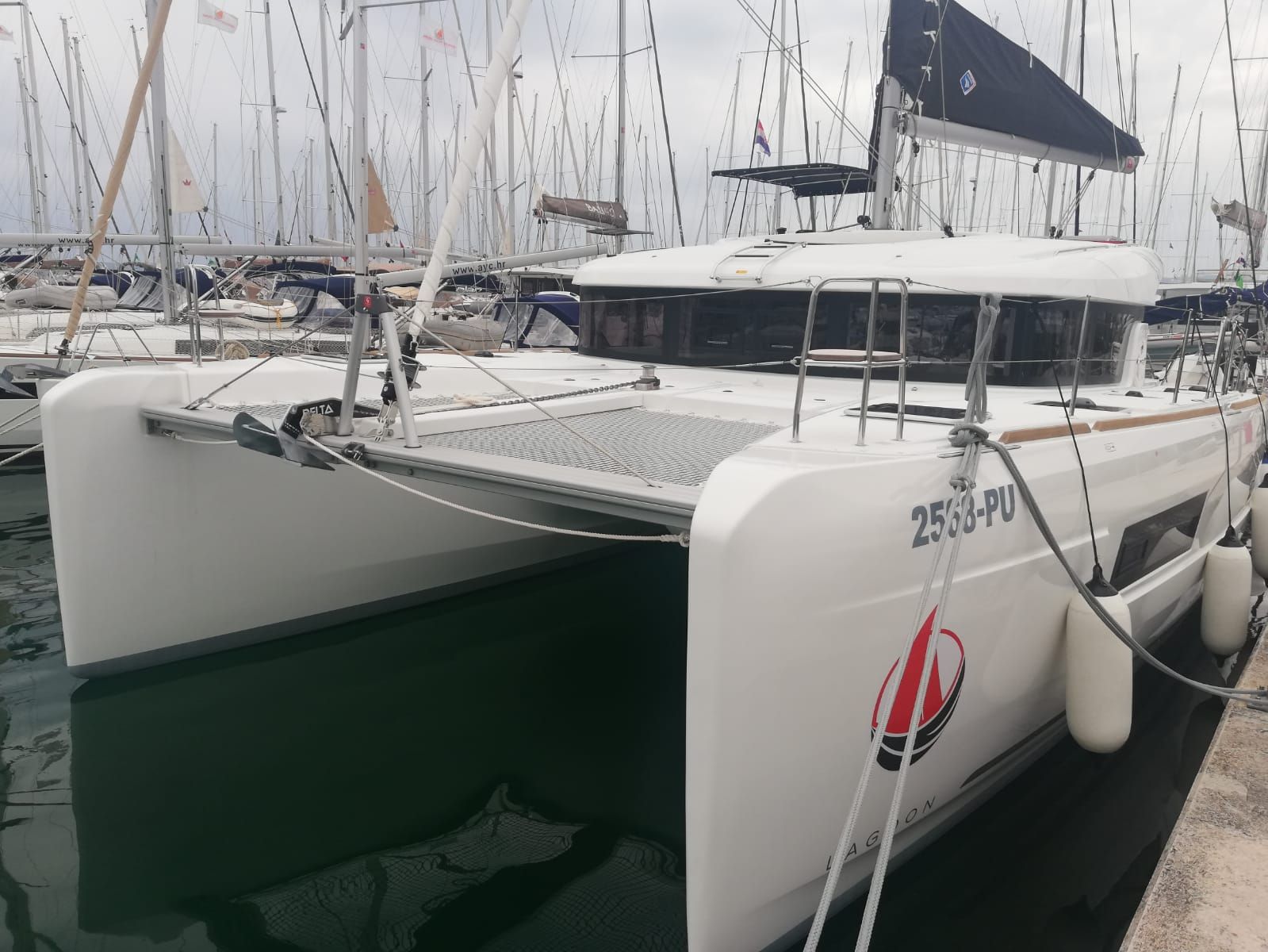 Un yacht blanc était amarré dans une marina, aux côtés d’autres bateaux.