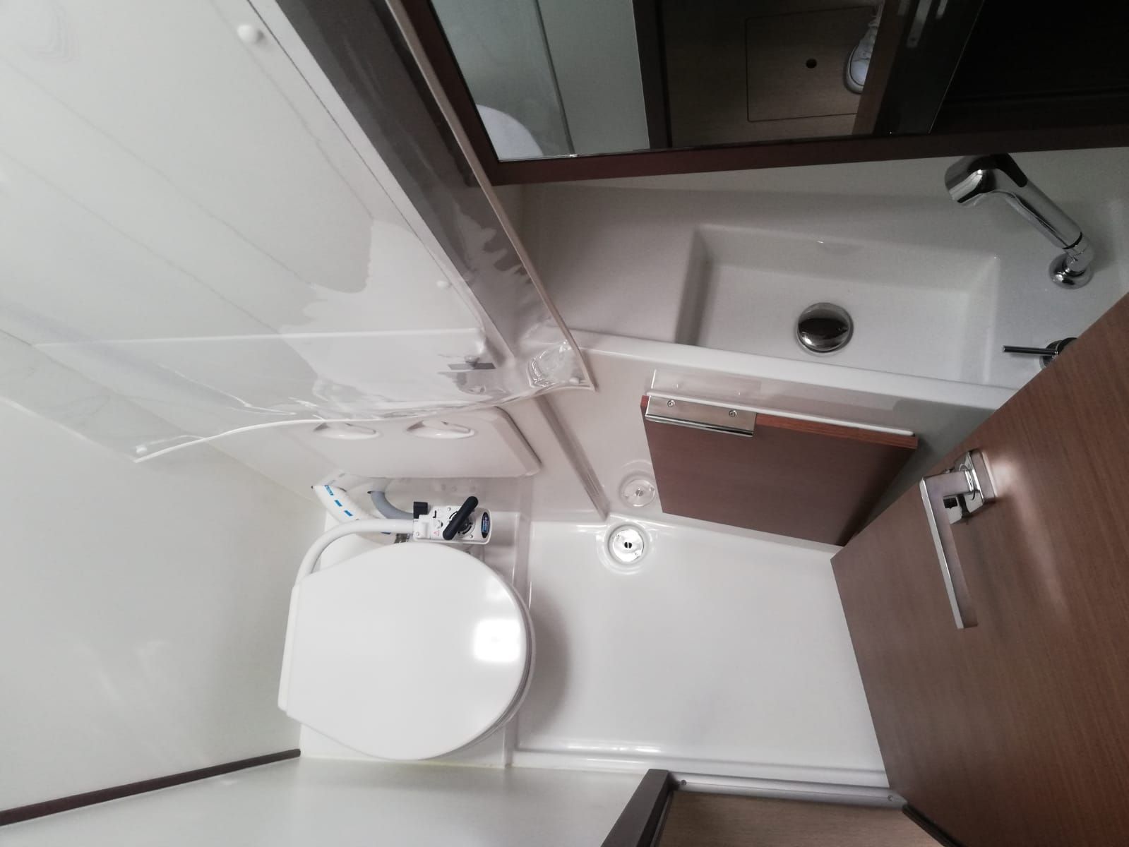 A compact bathroom with a white toilet, a sink, and a shower.