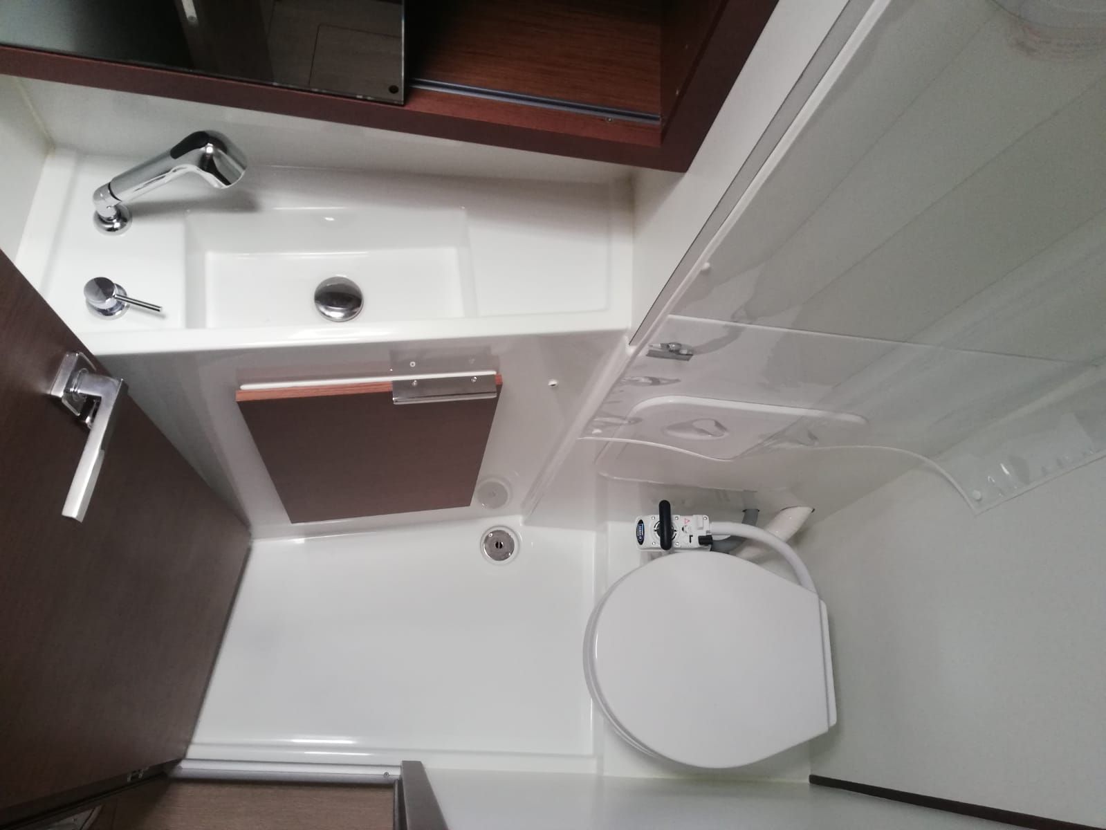 Een kleine badkamer met een wastafel, toilet en douche.
