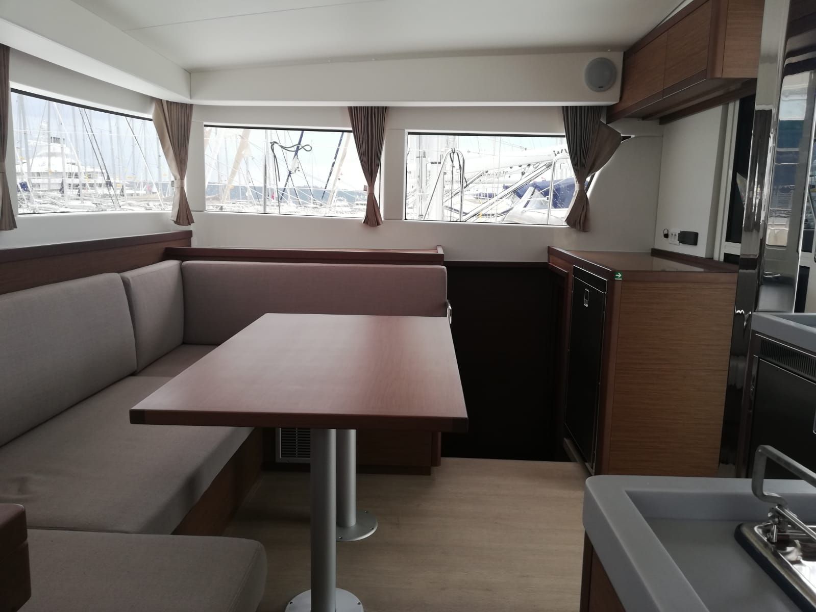 Une petite cuisine fonctionnelle comprenant un coin repas avec banquette, une petite table et un coin cuisine.