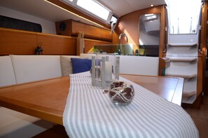 A modern interior with a wooden table, striped tablecloth, and a glass bowl on the table.