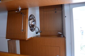 Una cocina compacta con armarios de madera, accesorios de acero inoxidable y un ventanal.
