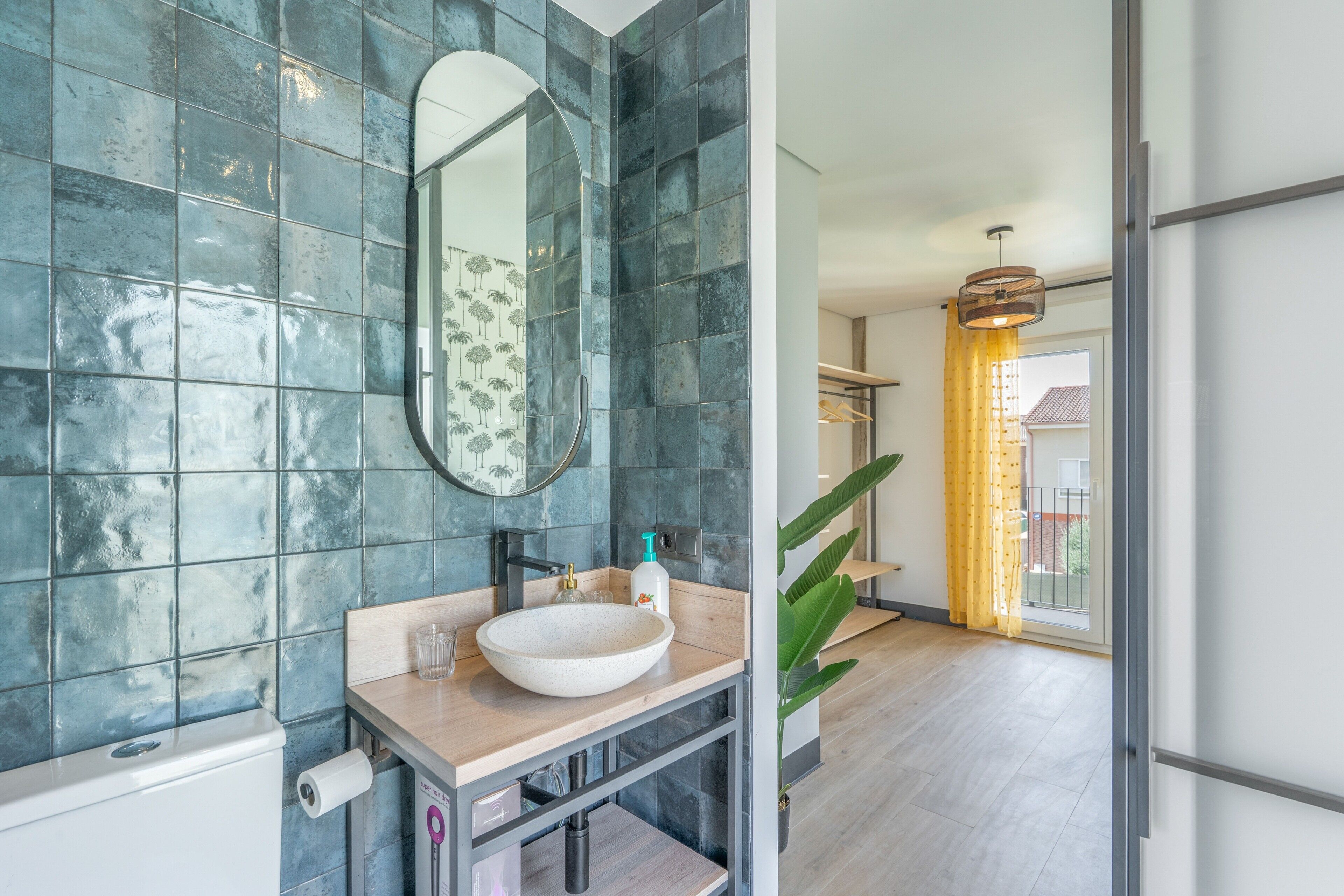 Un bagno con un grande specchio, un lavabo a incasso e un portasciugamani.