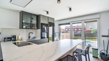 Uma cozinha moderna com uma ilha grande, eletrodomésticos embutidos e vista para o exterior.