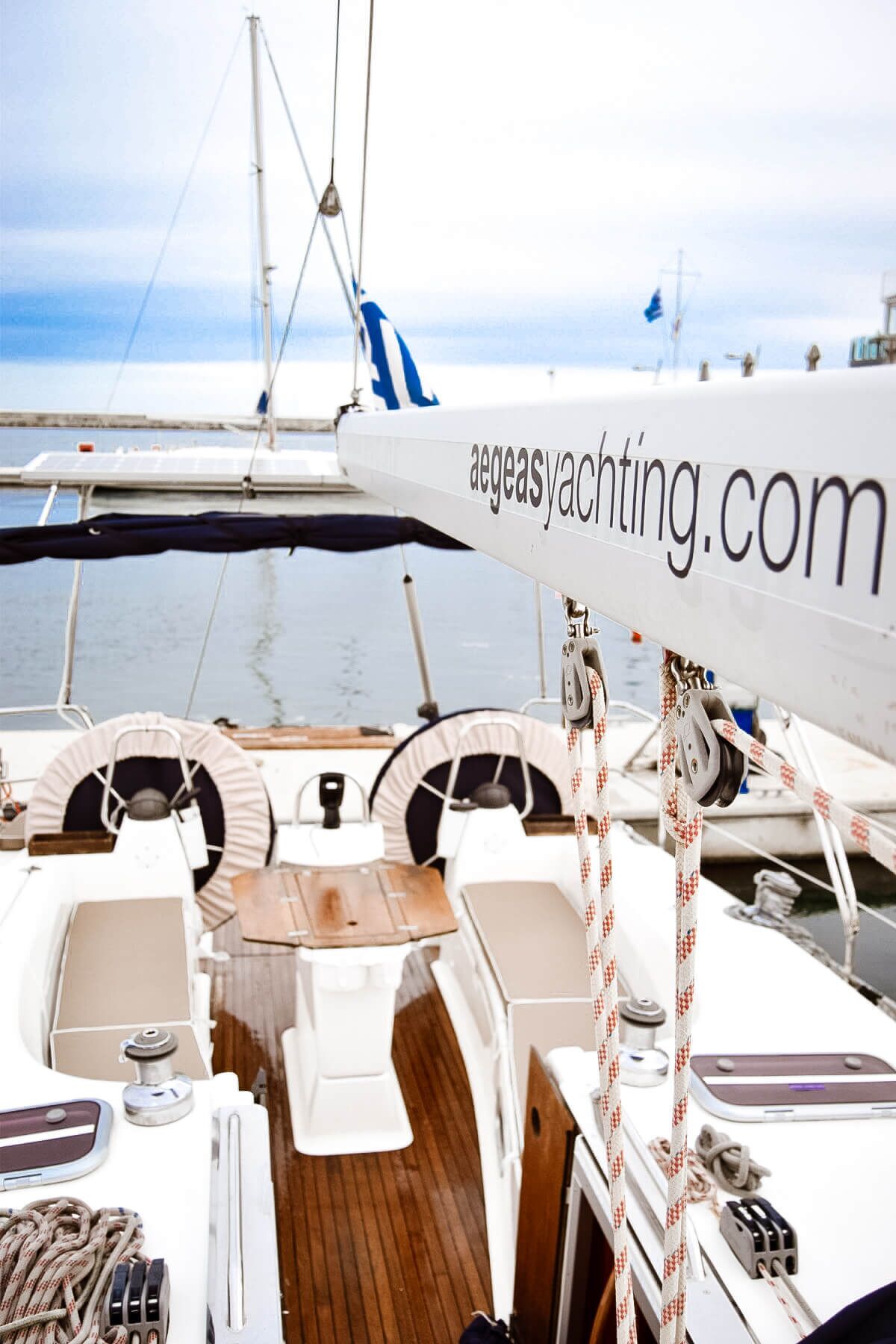 Eine Yacht mit einer Website-Adresse, einem Holldeck und Blick aufs Wasser.