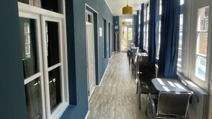 Un couloir doté d’un plancher en bois, de boiseries blanches et de murs bleus.