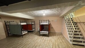 Une pièce avec des lits superposés, un escalier et un radiateur.