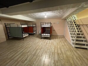 A room with bunk beds, a staircase, and a radiator.
