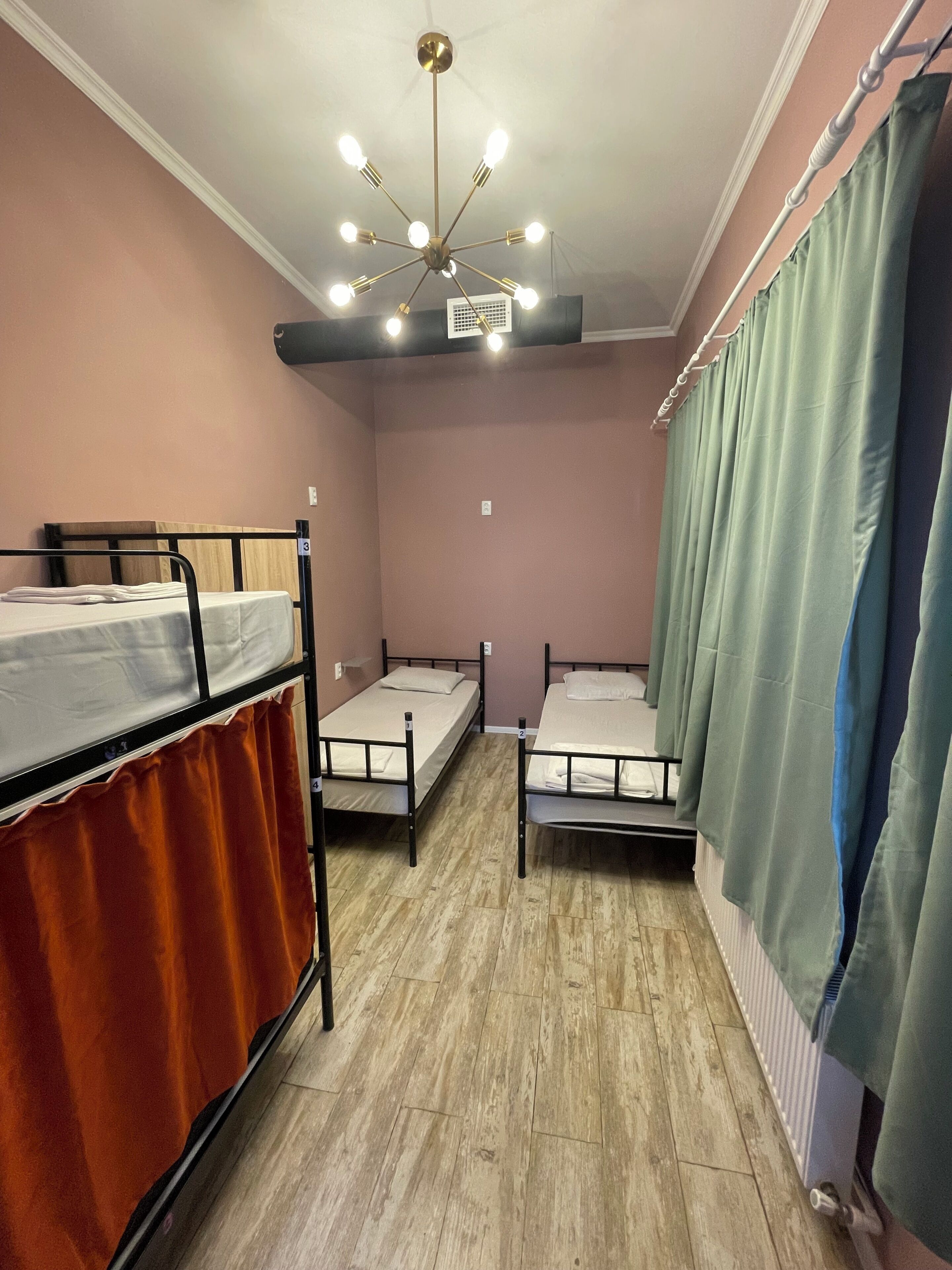 Une chambre avec des lits superposés, un ventilateur de plafond et un radiateur.