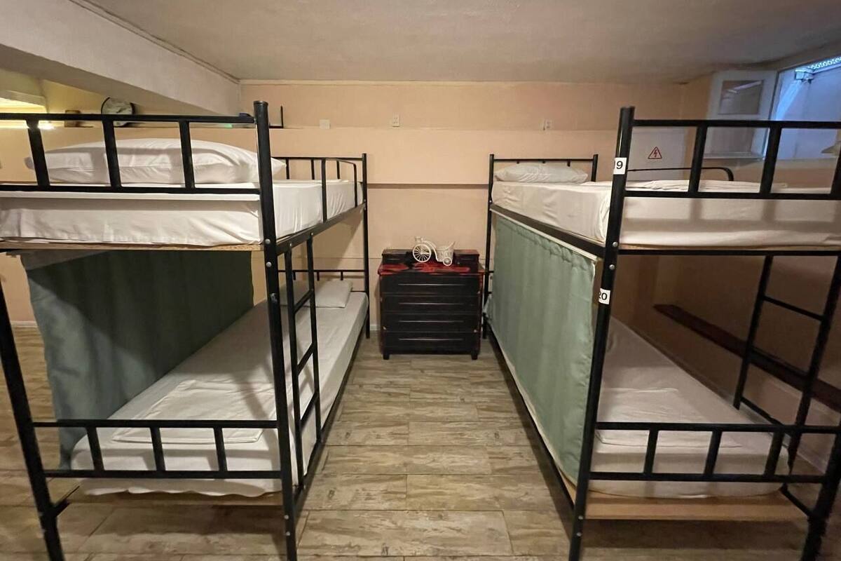 A room with bunk beds, a small table with a bicycle, and a radiator.