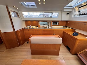 A compact kitchen with wooden cabinets, a microwave, and a small window.