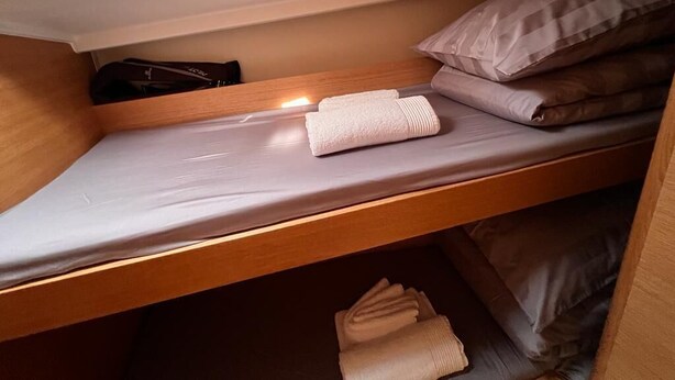 A bunk bed with a mattress, pillows, and folded towels. - Sun-Kissed Sailing Adventure in Split, Croatia (Kaštel Gomilica)