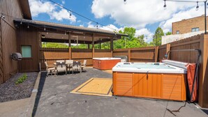 A backyard with a hot tub, outdoor seating, and a covered patio area. - King Suite, Hot Tubs, Cobden (Cobden)