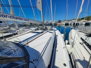 A marina with multiple sailboats docked, a clear blue sky, and a sign with 'charter.com'. - Sun-Kissed Sailing Adventure in Split, Croatia (Kaštel Gomilica)