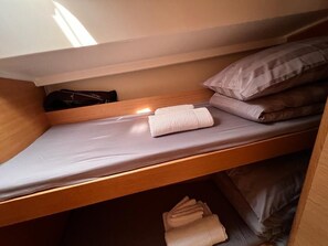 A bunk bed with a mattress, pillows, and folded towels. - Sun-Kissed Sailing Adventure in Split, Croatia (Kaštel Gomilica)