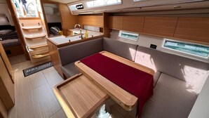 Een compact, goed verlicht interieur met een kitchenette, zithoek en ramen.