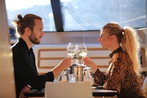 A dining table with two wine glasses, a bottle, and a metal container. - Sun-Kissed Sailing Adventure in Split, Croatia (Kaštel Gomilica)