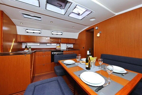A compact kitchen with modern appliances, a dining area with a table set for two, and a small seating area.