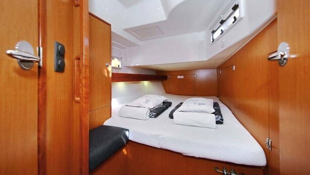 Ein kompaktes Blockhaus mit Bett, einer kleinen Sitzecke und einer Decke mit einer Lampe.